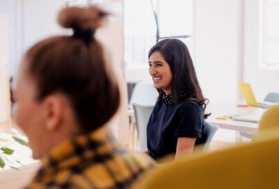 two women smiling in a meeting